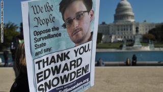 Demonstrators hold placards supporting former US intelligence analyst Edward Snowden during a protest against government surveillance on October 26, 2013 in Washington, DC. The disclosures of widespread surveillance by the US National Security Agency of US allies has caused an international uproar, with leaders in Europe and Latin America demanding an accounting from the United States. AFP PHOTO/Mandel NGAN (Photo credit should read MANDEL NGAN/AFP/Getty Images)
